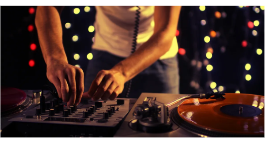 DJ decks lit by colourful bokeh lights in a club